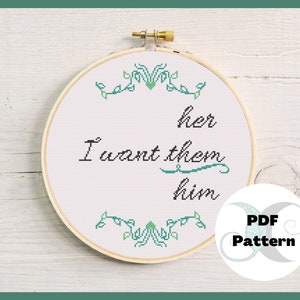 May include: A white embroidery hoop with a green floral design around the edge. The text "I want them her him" is stitched in black thread on a white background. The words "PDF Pattern" are printed in a circle with a green and blue design.