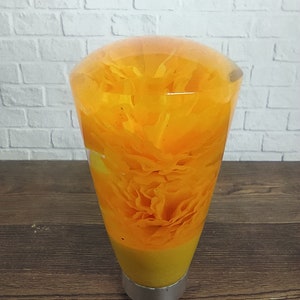 May include: A clear, yellow, resin gear shift knob with a yellow flower inside.