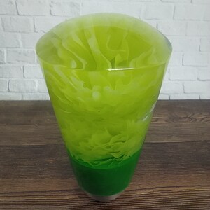 Könnte beinhalten: Ein grüner und weißer Resin-Schalthebelknauf. Die Oberseite des Knaufs ist hellgrün mit weißen Wirbeln. Die Unterseite des Knaufs ist einfarbig dunkelgrün.