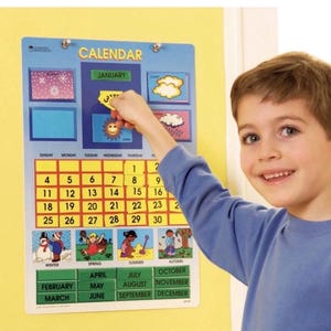 May include: A blue educational calendar with the word "CALENDAR" at the top. The calendar has sections for the days of the week, dates, and months. A child is placing a "3" sticker on the calendar. The calendar also has weather and seasonal illustrations.