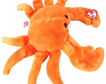 May include: Orange plush crab toy with a red Beanie Baby tag attached. The toy has a fuzzy texture and is shaped like a crab with large claws.