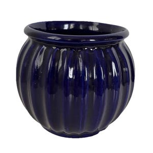 May include: A deep blue ceramic planter with a ribbed exterior. The planter has a rounded shape with a slightly flared rim. The glossy finish reflects light, highlighting the vertical ridges. This decorative pot is suitable for indoor or outdoor use.