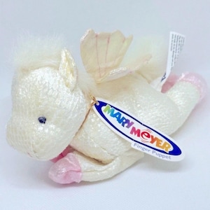 Może przedstawiać: Kremowa pacynka na palec w kształcie skrzydlatego konia. Pacynka ma białą grzywę, różowe kopyta i metkę z napisem "MARY MEYER Finger Puppet". Skrzydła są bladoróżowe. Zabawka dla dzieci.