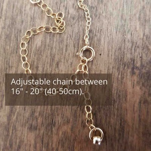 Puede incluir: Cadena de collar dorada con una longitud ajustable entre 40 y 50 cm. La cadena tiene un peque&ntilde;o cierre y una pieza final decorativa. El texto "Adjustable chain between 16" - 20" (40-50cm)" es visible.