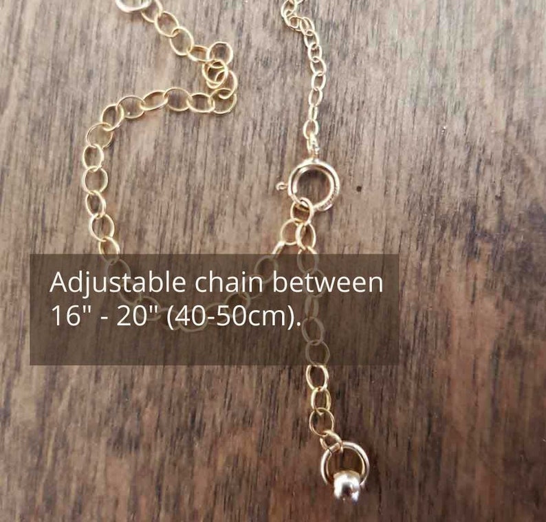 Puede incluir: Cadena de collar dorada con una longitud ajustable entre 40 y 50 cm. La cadena tiene un peque&ntilde;o cierre y una pieza final decorativa. El texto "Adjustable chain between 16" - 20" (40-50cm)" es visible.