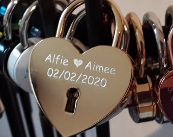 May include: Gold heart-shaped padlock with the inscription "Alfie ♥ Aimee 02/02/2020".