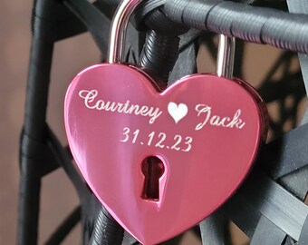 May include: Pink heart-shaped padlock with the inscription "Courtney ♥ Jack 31.12.23".