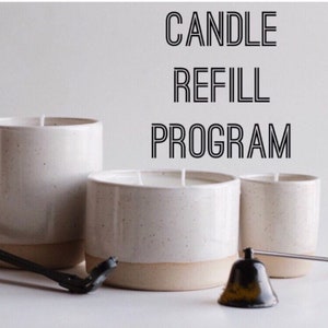 May include: Three off-white speckled ceramic candle vessels of varying heights and widths, each with a single or double wick. The text CANDLE REFILL PROGRAM is displayed in black. A black metal wick trimmer and a bell-shaped candle snuffer are present.