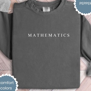 May include: A dark gray sweatshirt with the word "MATHEMATICS" printed in white on the front.