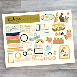 May include: A sheet of stickers with an April and Easter theme. The stickers include various designs, such as flowers, bunnies, eggs, and the words "Spring", "April", and "He is Risen".