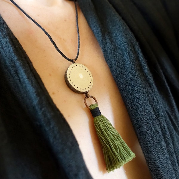 Collier rondelle de bois et pompon de fil vert sur cordon de chanvre