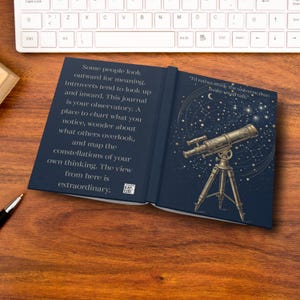 May include: Open journal with a dark blue cover featuring a telescope illustration and text. The left page has text about introspection and observation. The right page has a telescope image with stars and the quote, "I'd rather study the universe, than make small talk."