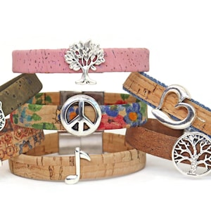 May include: A collection of cork bracelets with various designs and silver-tone charms. The bracelets feature different patterns and colors, including floral, pink, and natural cork. Charms include a tree, peace sign, hand, heart, and musical note.