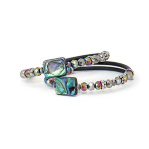May include: Abalone shell bracelet with square abalone shell beads and iridescent beads. The bracelet has a black band and silver-colored accents. The bracelet is a spiral design.