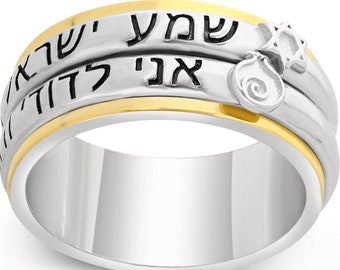 May include: A silver and gold spinning ring with Hebrew text and a Star of David charm. The ring has a smooth, polished finish.