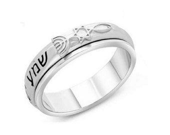 May include: A silver spinning ring with a Star of David, a menorah, and the Hebrew word "Shabbat" engraved on the band.