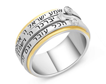 May include: A silver and gold spinning ring with Hebrew text and a hand and star of David design.