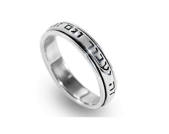 May include: A silver ring with Hebrew text inscribed around the band.