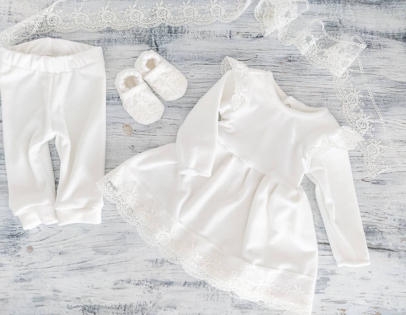 Pu&ograve; includere: Un vestitino bianco per neonata con pizzo e maniche lunghe, un paio di leggings bianchi per neonata e un paio di scarpine bianche per neonata.