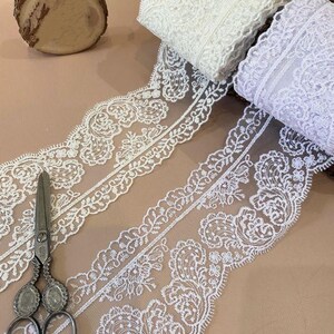 Pu&ograve; includere: Due rotoli di pizzo bianco con un delicato motivo floreale. Il pizzo &egrave; morbido e fluido, perfetto per aggiungere un tocco di eleganza a qualsiasi progetto.
