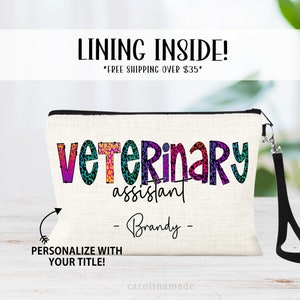 May include: A white canvas makeup bag with a black zipper and a black strap. The bag has a rainbow-colored text that says "Veterinary assistant - Brandy -" with a leopard print pattern. The text "PERSONALIZE WITH YOUR TITLE!" is below the bag.