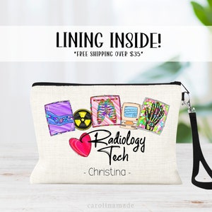 May include: A white canvas makeup bag with a black zipper and a black strap. The bag has a colorful design with images of x-rays, a heart, and the text "Radiology Tech - Christina - "