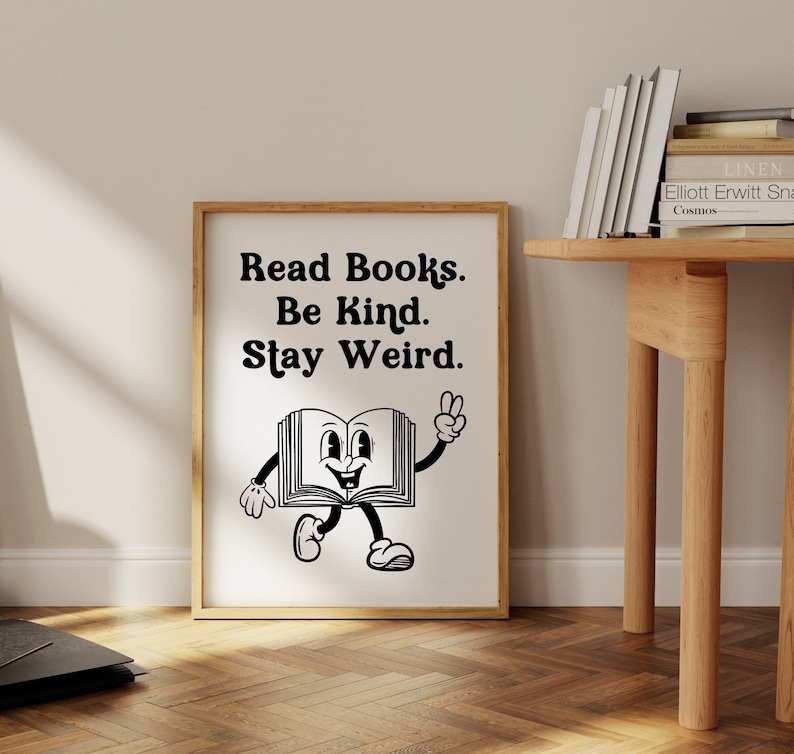 Puede incluir: Impresi&oacute;n en blanco y negro con el texto "Read Books. Be Kind. Stay Weird." y un personaje de libro de dibujos animados con una cara sonriente y brazos y piernas.
