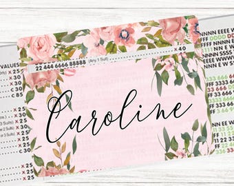 May include: A light pink card with the name "Caroline" in elegant script. The card is adorned with watercolor-style pink roses and green foliage. The top edge has a floral border and the text "22 444 6666 88888 (Any 1 Sut) ...x40". The bottom corner has the text "carolinamade".
