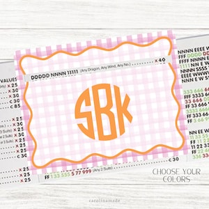 May include: A personalized card with a pink and white gingham pattern and an orange border. The card features the initials "SBK" in a circular design. The text "CHOOSE YOUR COLORS" is visible.