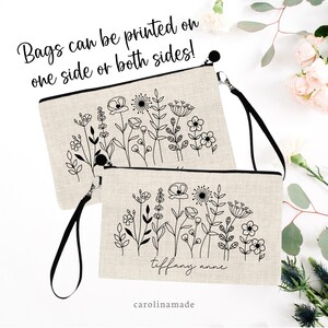 Pu&ograve; includere: Due pochette beige con cerniera e cinturini neri. Le pochette presentano un disegno a linea nera di fiori e vegetazione. La pochette inferiore ha il nome "tiffany anne" scritto in corsivo nero. Il testo "Bags can be printed on one side or both sides!" &egrave; scritto in nero nella parte superiore dell'immagine. Il testo "carolinamade" &egrave; scritto in nero nella parte inferiore dell'immagine.
