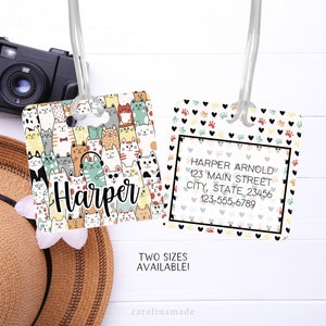 May include: Two luggage tags with a cat pattern. One tag has the name "Harper" in black text and the other tag has the name "Harper Arnold" with an address and phone number. The tags are both white with a black border.