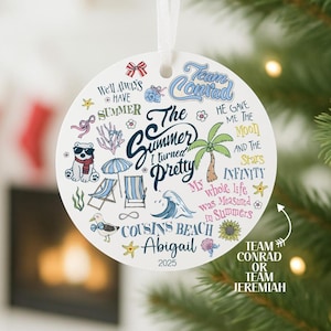 May include: A round, white ceramic ornament with a summer theme. It features illustrations of a bear, beach chairs, a palm tree, and text that reads "The Summer I Turned Pretty" and "Cousins Beach Abigail 2025".