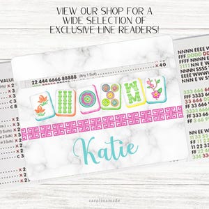 May include: A white marble-patterned line reader with a pink border and the name "Katie" in teal script. The line reader features colorful Mahjong tile designs and the text "VIEW OUR SHOP FOR A WIDE SELECTION OF EXCLUSIVE LINE READERS!"