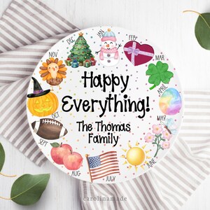 May include: A white ceramic plate with colorful illustrations representing the months of the year. The plate features a Christmas tree, snowman, heart, shamrock, egg, butterfly, flowers, sun, American flag, apples, football, pumpkin, and turkey. Text reads "Happy Everything!" and "The Thomas Family."