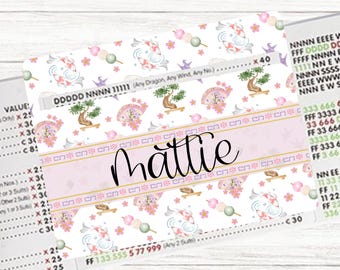 May include: A personalized sticker sheet featuring a Japanese-inspired design. The sheet includes a pink banner with the name "Mattie" in cursive, surrounded by koi fish, bonsai trees, and cherry blossoms. The background is white with various text and number details.