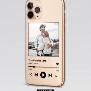 Könnte beinhalten: Eine transparente Handyhülle mit goldener Einfassung und einem Foto eines sich umarmenden Paares. Die Hülle hat ein Musikplayer-Design mit dem Text "Your Favorite Song" und "Artist's name". Der Musikplayer hat einen Play-Button, einen Pause-Button, einen Vorspul-Button und einen Rückspul-Button.