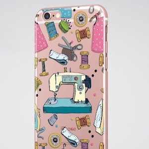 Puede incluir: Una funda rosa para iPhone con un patrón colorido de artículos de costura, que incluye una máquina de coser, carretes de hilo, tijeras, botones y una aguja e hilo. El texto "ZOO BIZU" está impreso en la parte inferior de la funda.