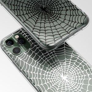 Peut inclure: Une coque de t&eacute;l&eacute;phone transparente avec un motif d'araign&eacute;e noir et blanc. La coque est con&ccedil;ue pour s'adapter &agrave; un iPhone avec un appareil photo &agrave; trois objectifs.