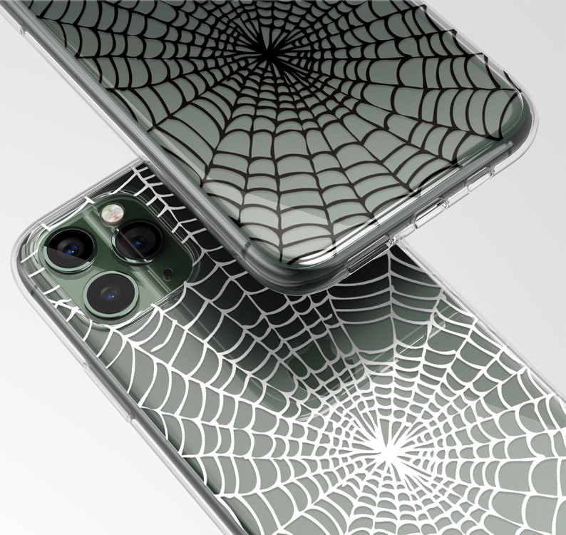 Peut inclure: Une coque de t&eacute;l&eacute;phone transparente avec un motif d'araign&eacute;e noir et blanc. La coque est con&ccedil;ue pour s'adapter &agrave; un iPhone avec un appareil photo &agrave; trois objectifs.