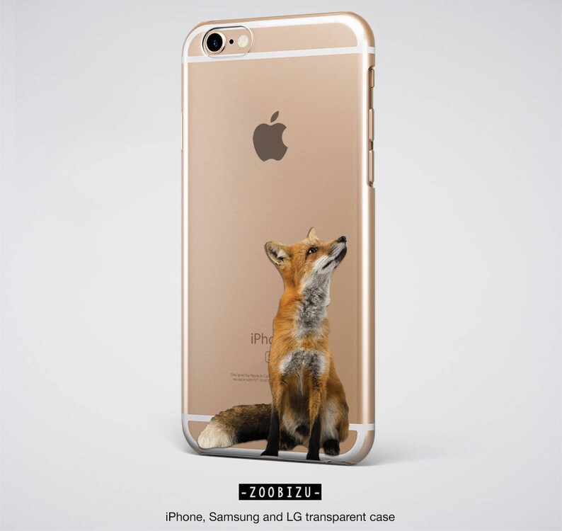 Op de afbeelding: Een gouden iPhone-hoes met een rode vos die omhoog kijkt. De vos zit op zijn achterpoten met zijn staart om zijn lichaam gewikkeld. De hoes heeft een transparante achterkant en een gouden frame.
