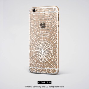 Peut inclure: Une coque de t&eacute;l&eacute;phone transparente avec un motif de toile d'araign&eacute;e blanche. La coque est compatible avec les t&eacute;l&eacute;phones iPhone, Samsung et LG.