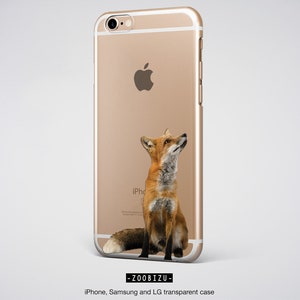 Op de afbeelding: Een gouden iPhone-hoesje met een transparante achterkant waarop een rode vos omhoog kijkt. Het hoesje heeft de tekst "iPhone" op de achterkant.