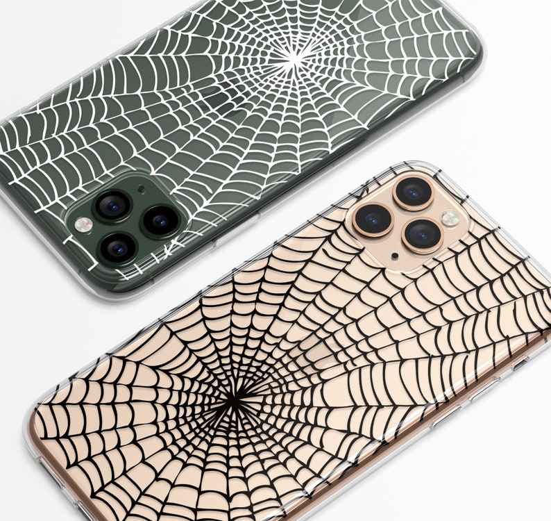 Peut inclure: Deux coques de t&eacute;l&eacute;phone transparentes avec un motif de toile d'araign&eacute;e. Une coque a une toile d'araign&eacute;e blanche sur un fond vert fonc&eacute;. L'autre coque a une toile d'araign&eacute;e noire sur un fond beige clair.