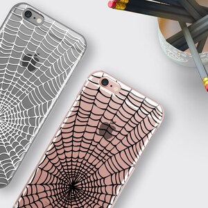 Peut inclure: Deux coques de t&eacute;l&eacute;phone iPhone avec un motif de toile d'araign&eacute;e. Une coque est transparente avec une toile d'araign&eacute;e blanche, et l'autre coque est transparente avec une toile d'araign&eacute;e noire.