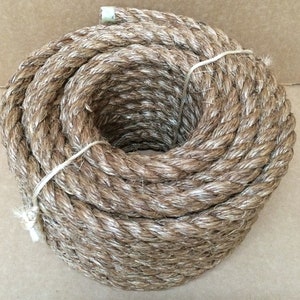 May include: A coil of natural fiber rope, likely made of sisal or hemp, with a brown color. The rope is tightly wound and has a rough texture.