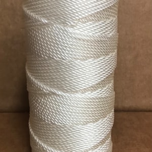 May include: A white spool of braided nylon rope.