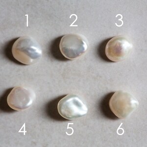 May include: Six white baroque pearls with iridescent highlights, numbered 1 through 6.