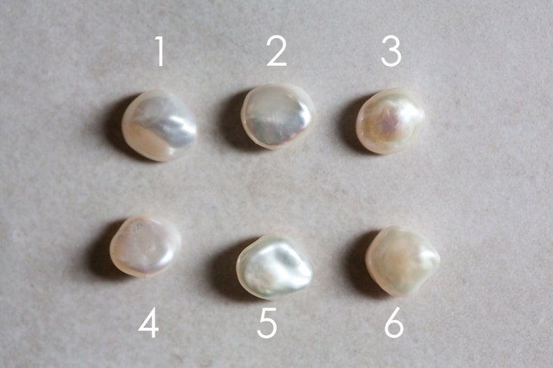 May include: Six white baroque pearls with iridescent highlights, numbered 1 through 6.