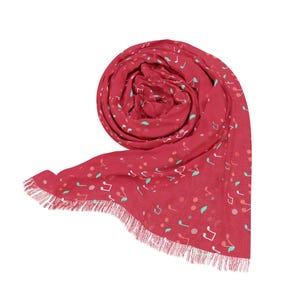 May include: A rolled-up, red scarf with a white fringe. The scarf is decorated with white musical notes, small teal leaves, and pink and teal dots. The scarf is made of a lightweight fabric.