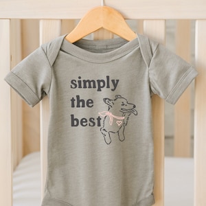 Può includere: Un body per neonato di colore grigio con maniche corte e un'immagine di un cane con la scritta "simply the best".